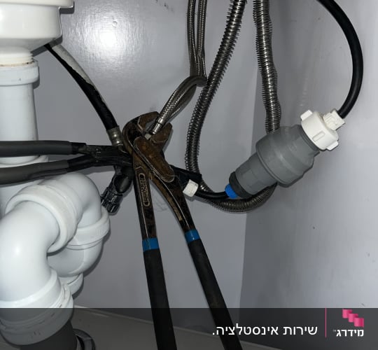 עבודת אינסטלציה וחיבור צינורות גמישים לברז מתחת לכיור